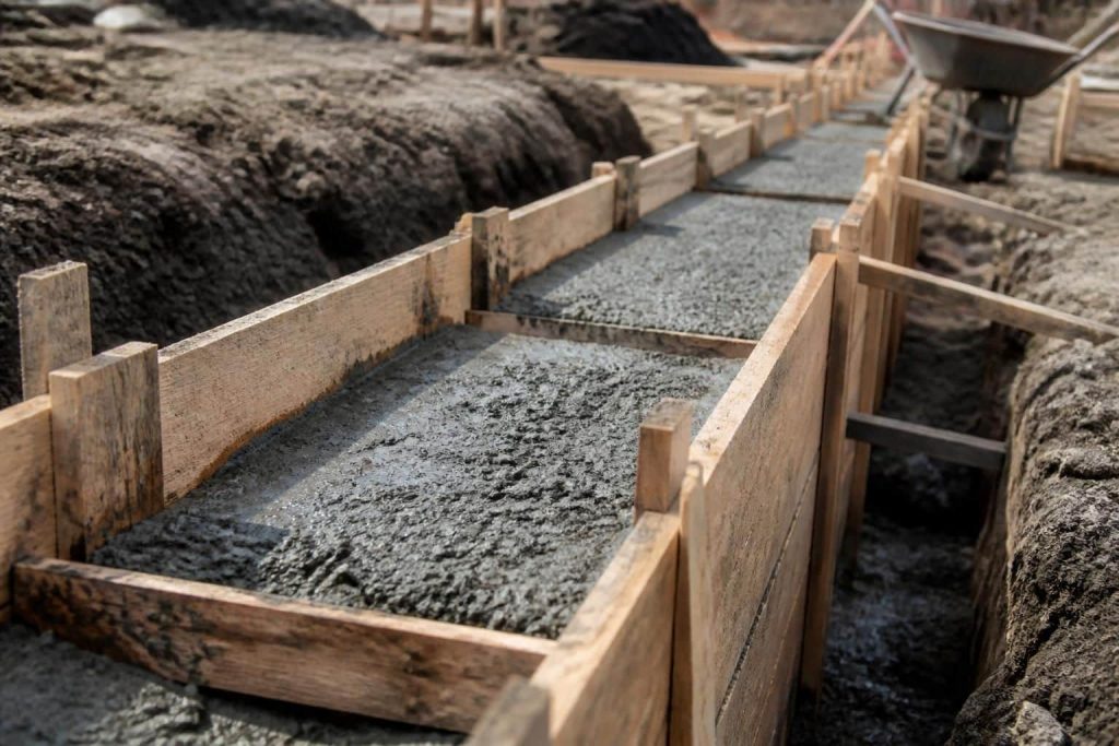 découvrez l'importance du coffrage en bois dans le maintien du béton coulé lors des fondations et optimisez la planification de vos travaux de construction.